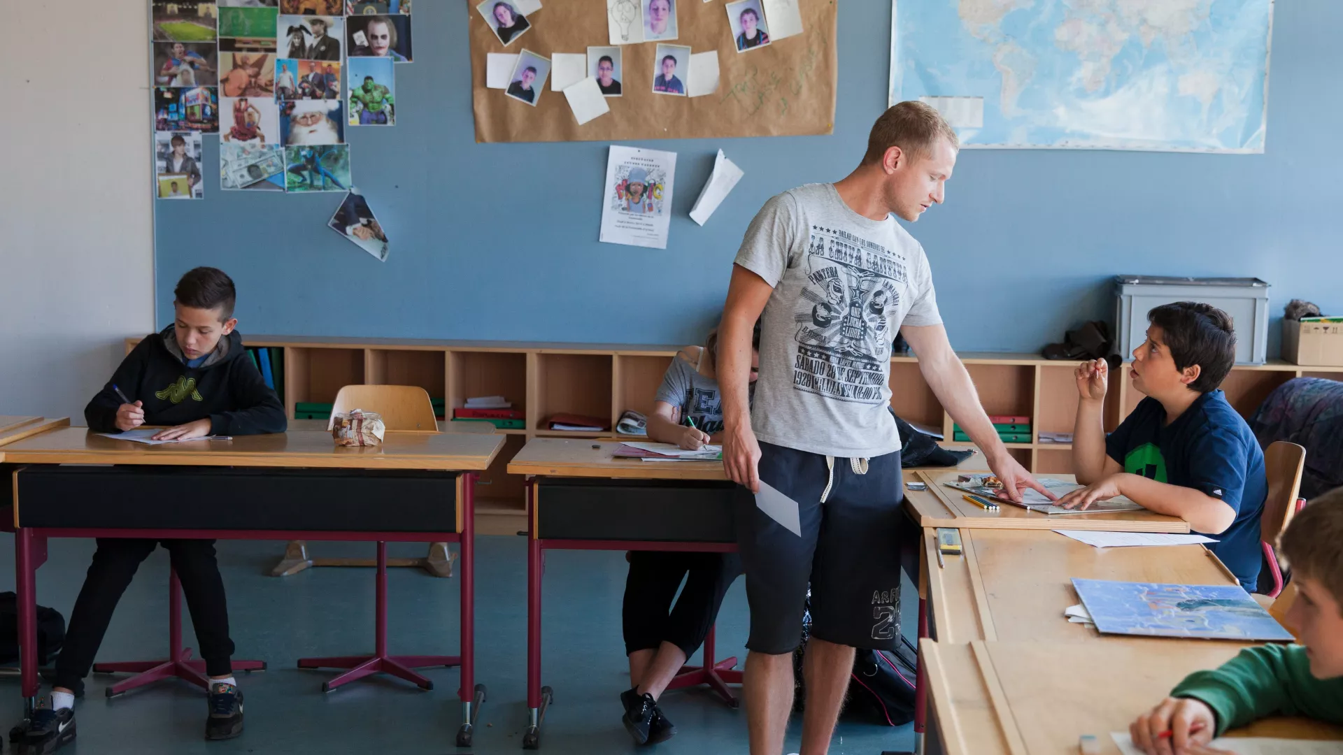 enseignant devant tables élèves