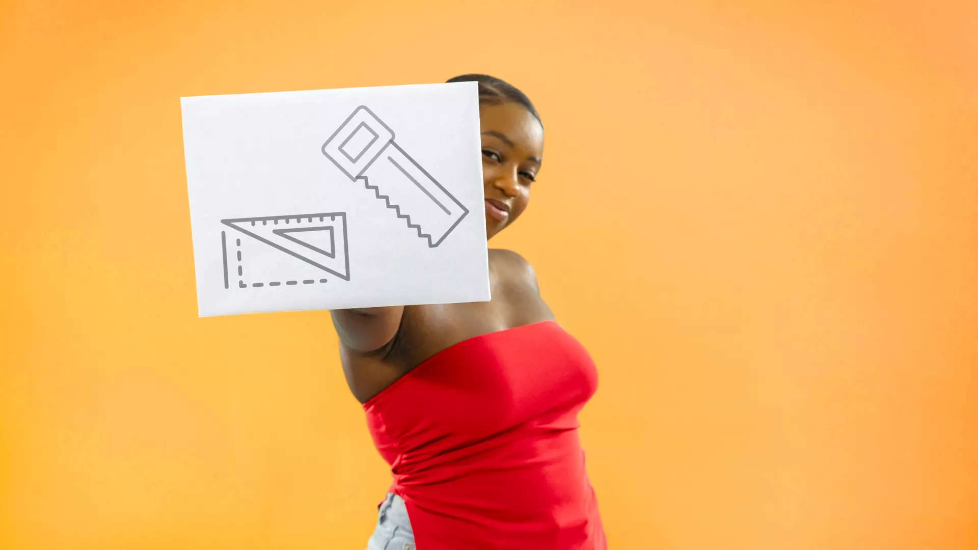 Personne qui tient une pancarte avec des pictogrammes qui représnentent le métier de menuisier