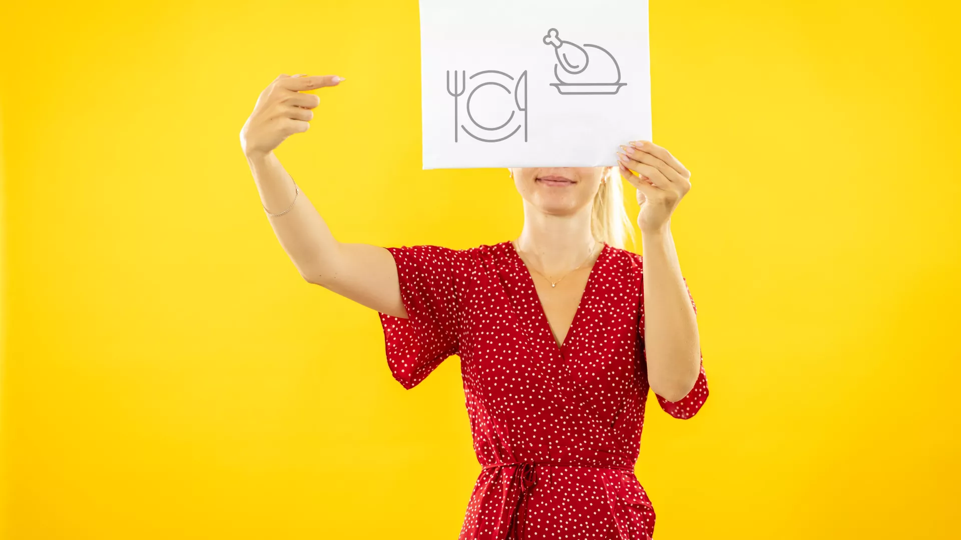 Personne qui tient une pancarte avec des pictogramme d'employé·e de cuisine