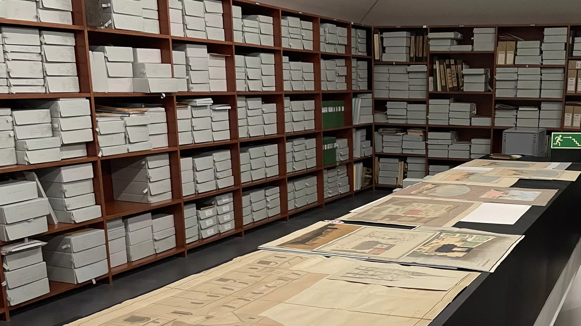 Vue d'étagères de cartons d'archives et de plans anciens