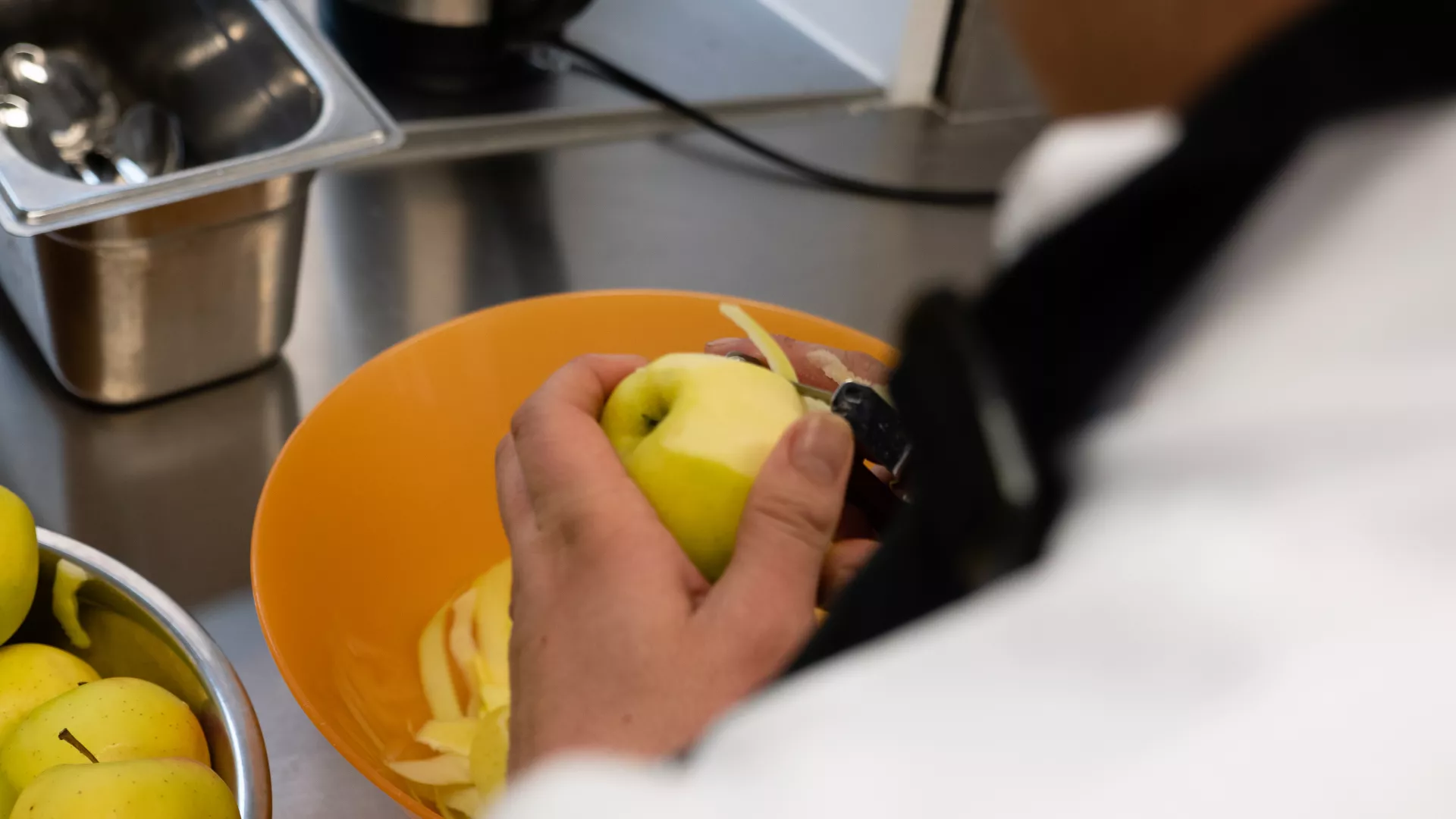 une personne pèle une pomme