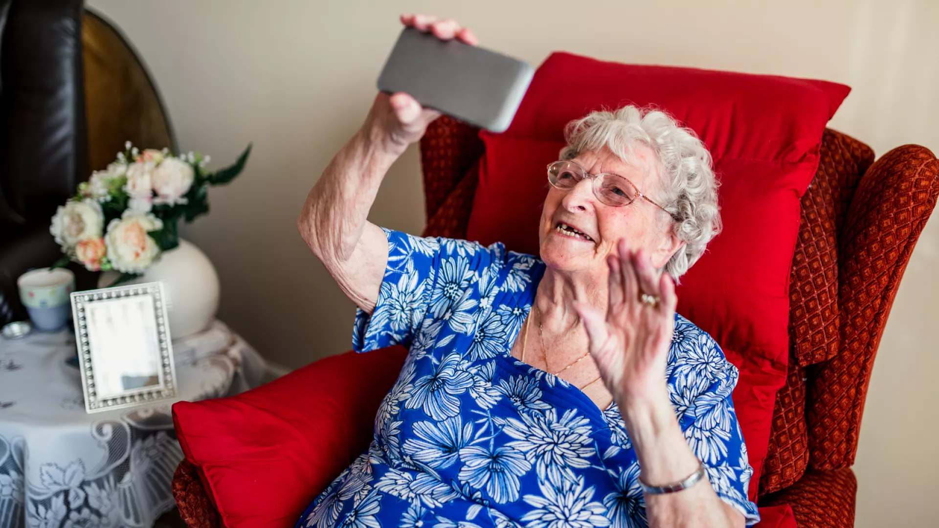 Une personne âgée seule chez elle en conversation téléphonique.