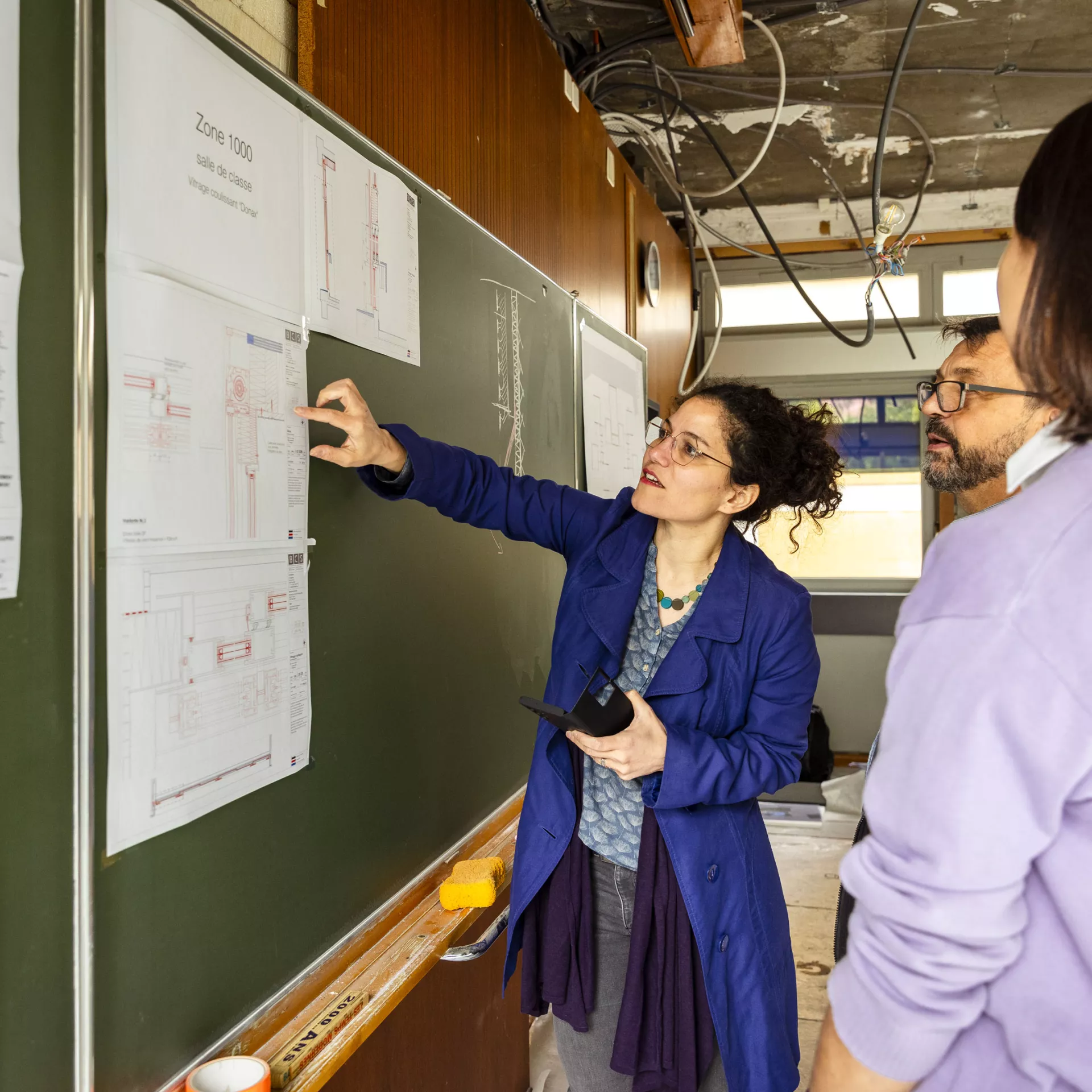 Personnes devant un tableau qui regardent une démonstration de plan