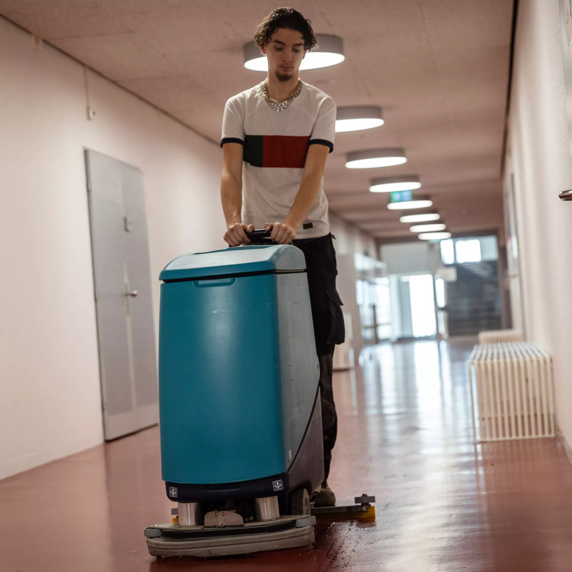 Personne qui passe une machine dans un couloir